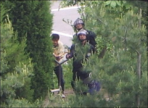 오산세교지구 철거민 농성 현장에서 사복경찰관으로 보이는 사람과 전경들이 제작한 대형 철재 '새총'으로 농성장을 향해 조준 공격하고 있다. 